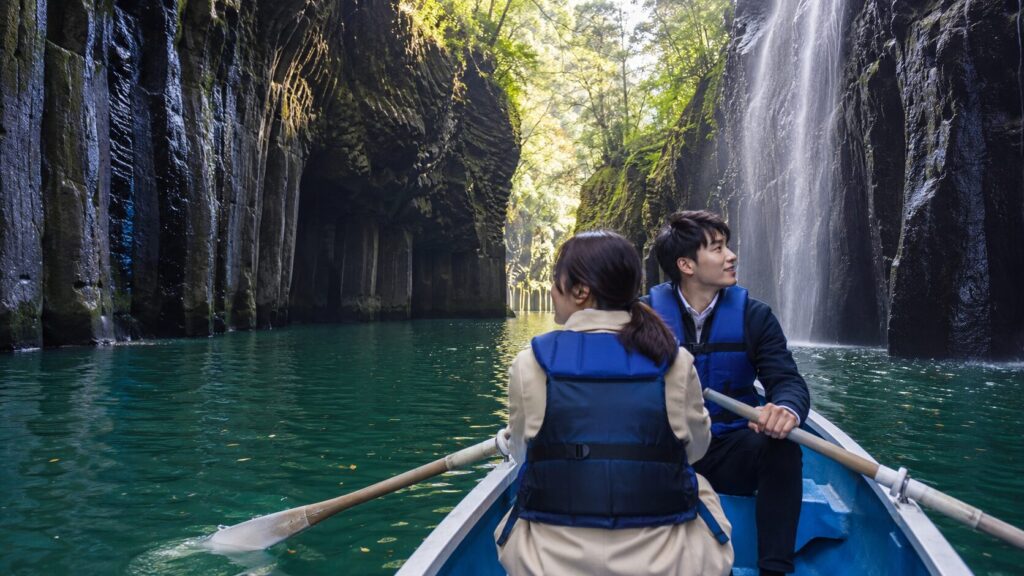 高千穂峡の貸しボートから真名井の滝を眺める旅行者
